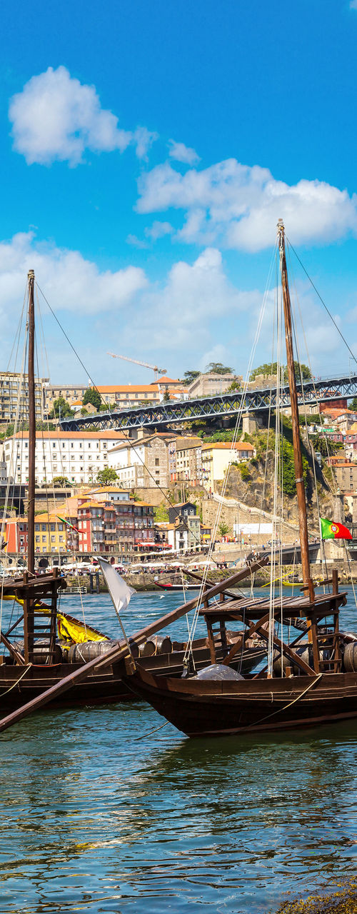 Traditional boats on river beneath arched bridge