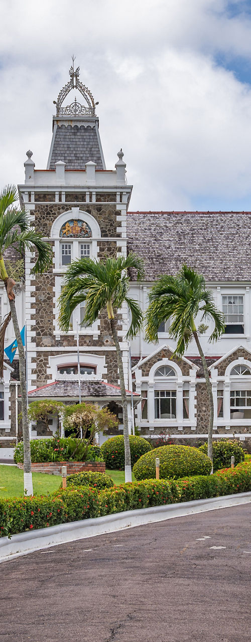 Colonial-style mansion with palm trees and garden drive