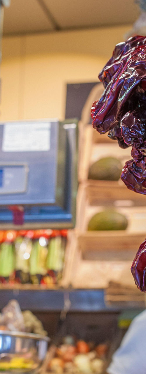 Fresh produce market with hanging dried peppers