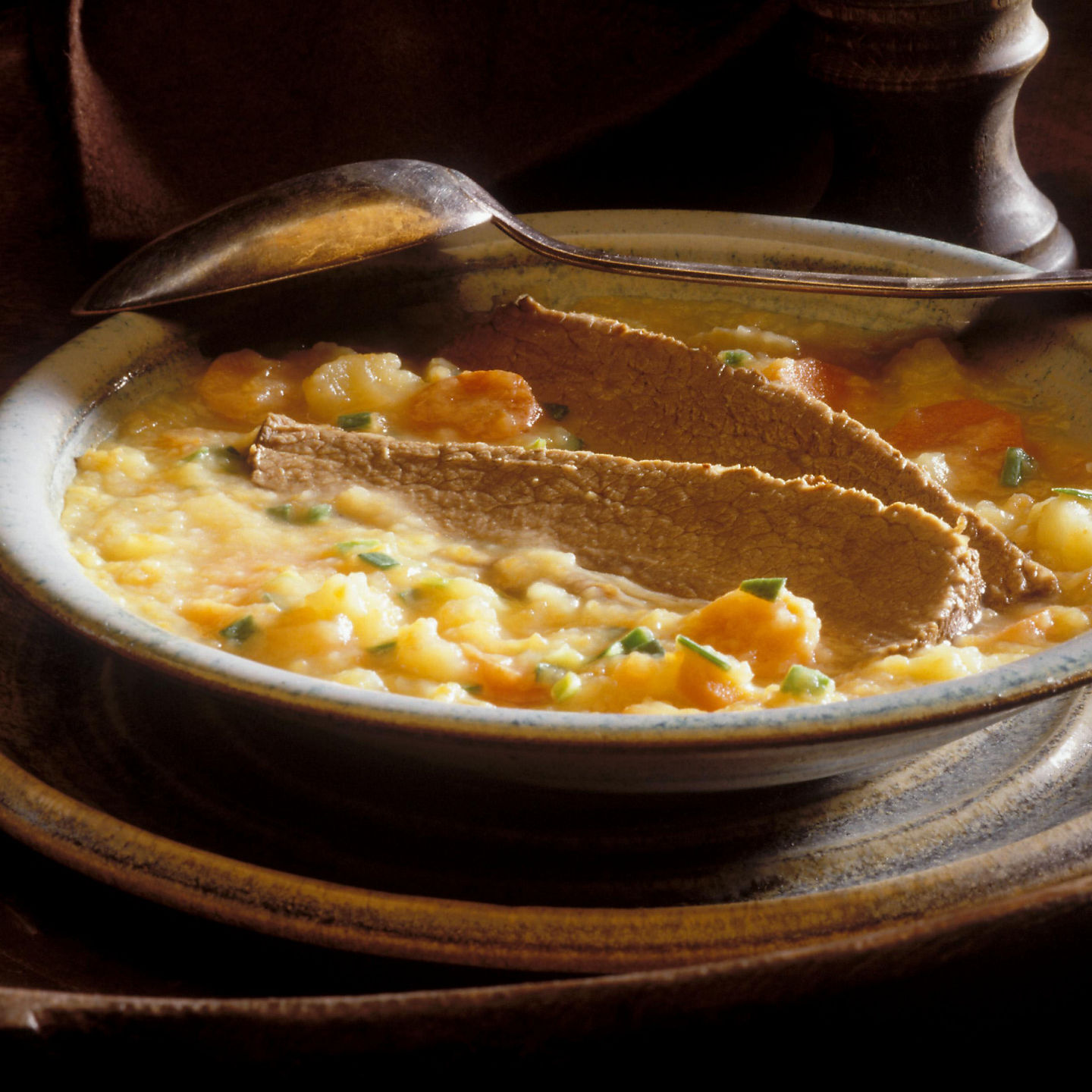 Rustic soup in ceramic bowl with spoon