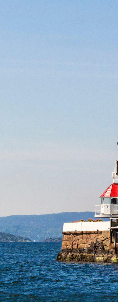 Lighthouse on rocky island in calm waters