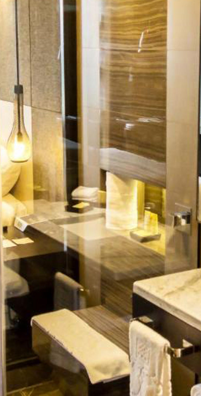 Modern hotel room with glass-walled bathroom