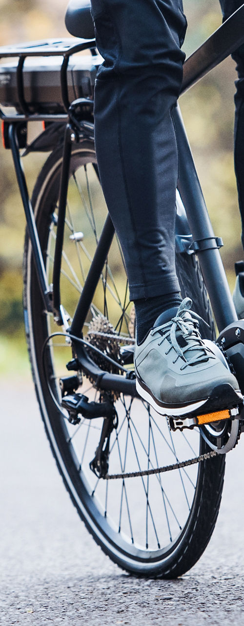 Person riding electric bicycle on autumn road
