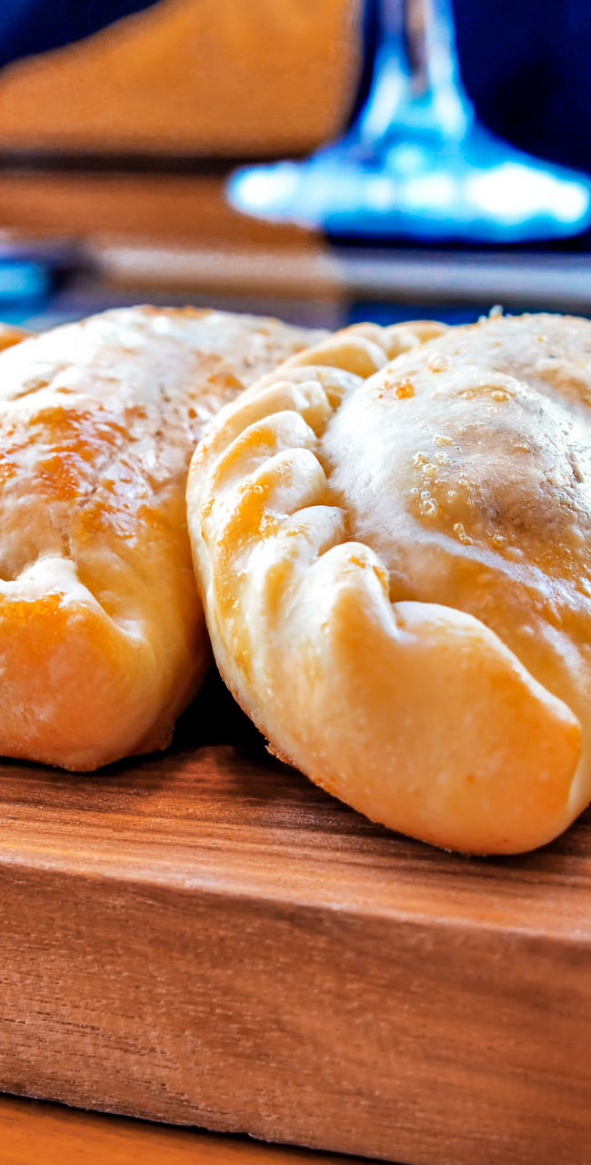 Freshly baked empanadas on wooden platter