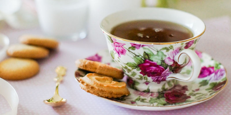 Floral teacup with biscuits on pastel table
