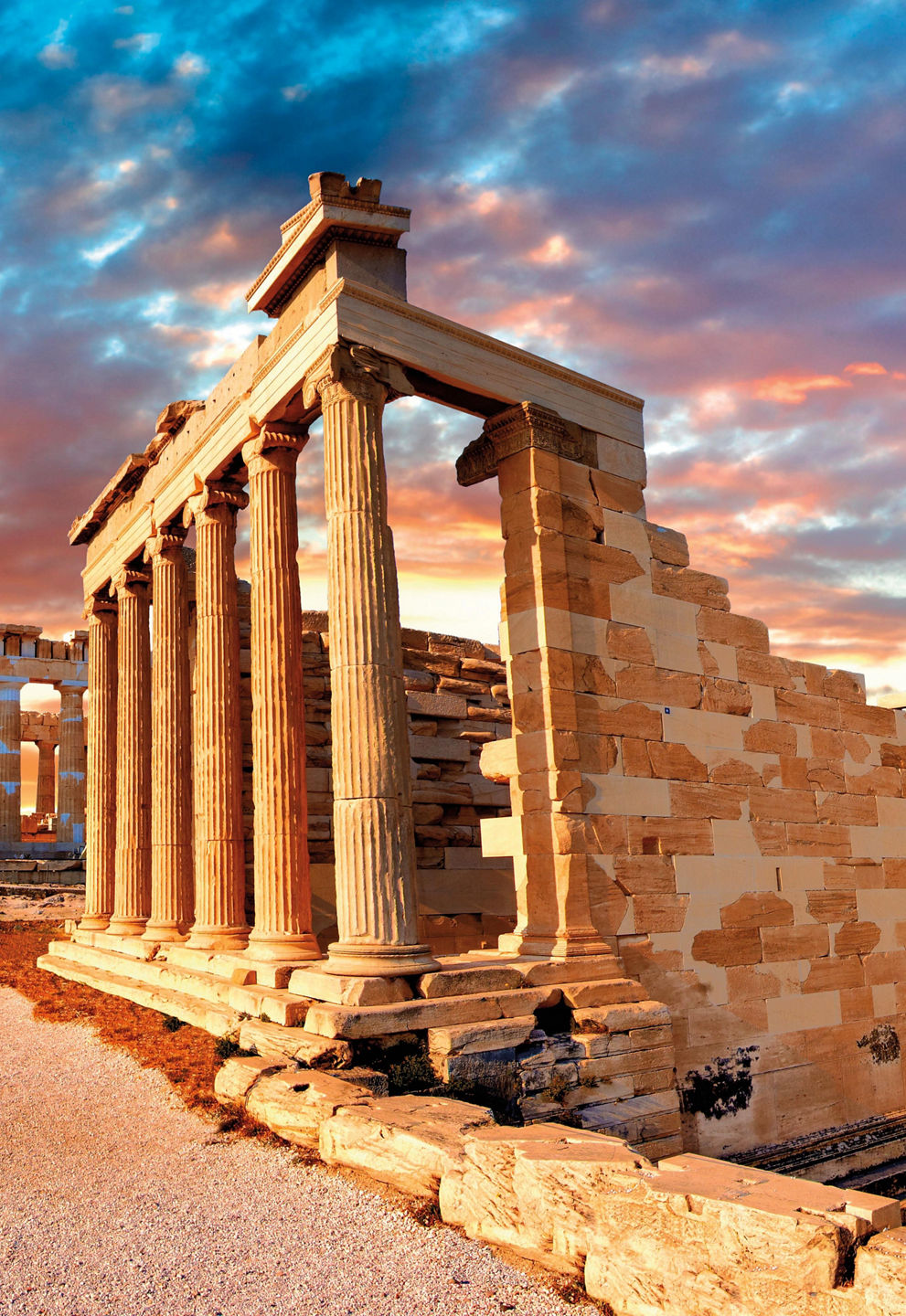 Ancient Greek ruins under vibrant sunset