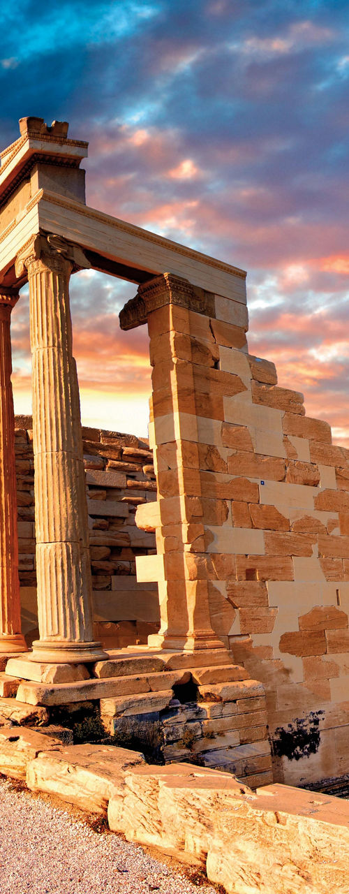 Ancient Greek ruins under vibrant sunset