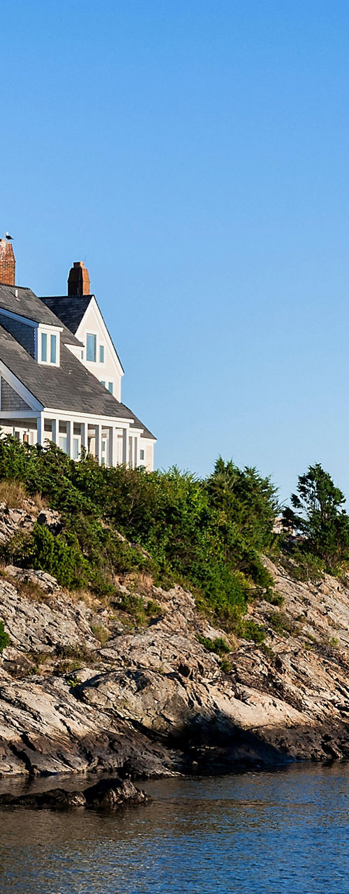 Coastal house on rocky shoreline with ocean view