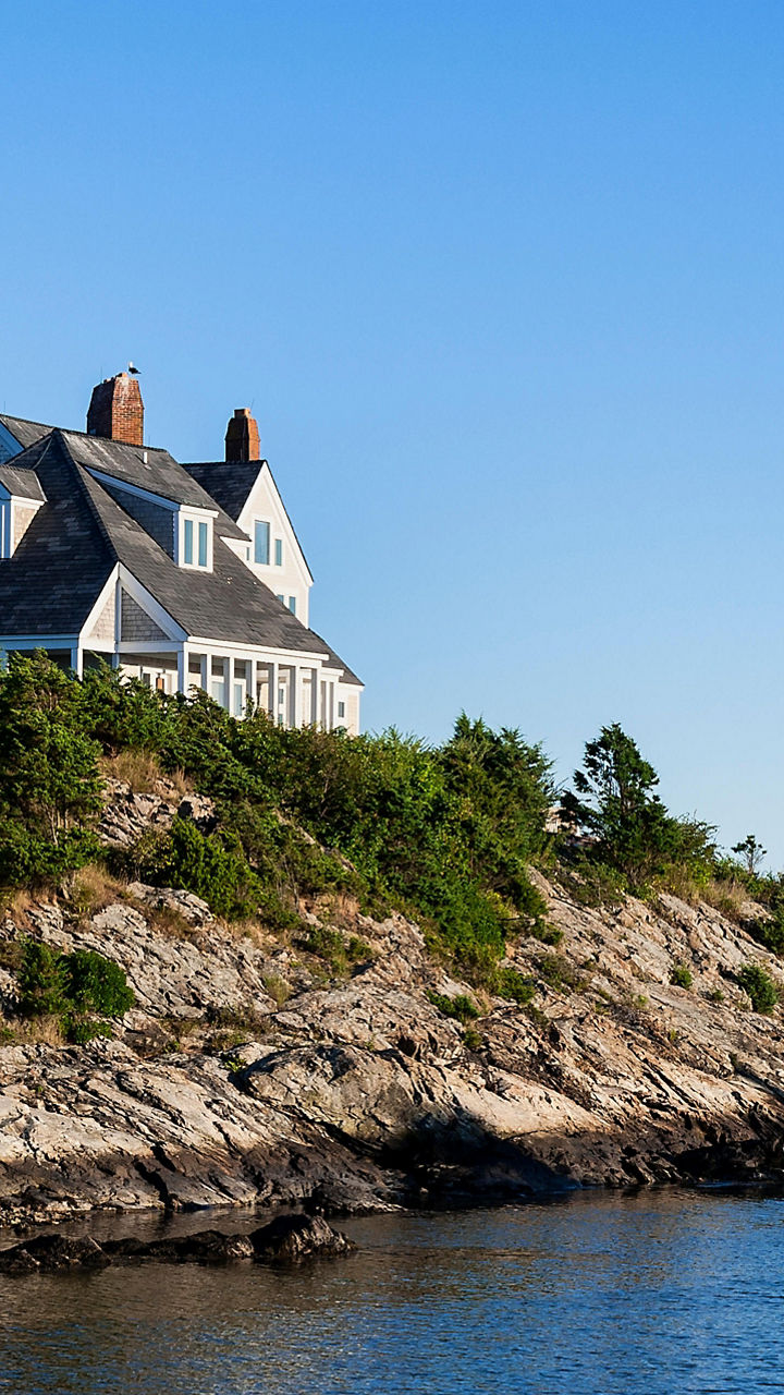 Coastal house on rocky shoreline with ocean view