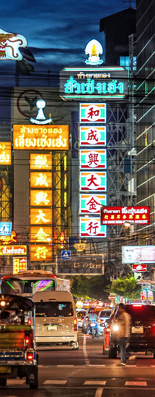 Bustling Chinatown street at night, neon signs