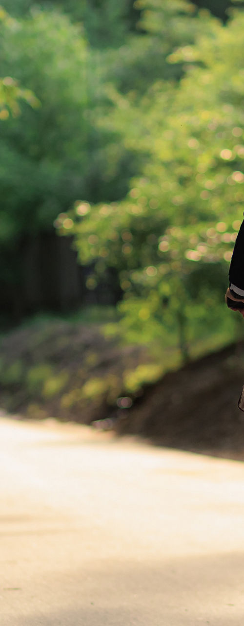 Cyclist riding along tree-lined park path