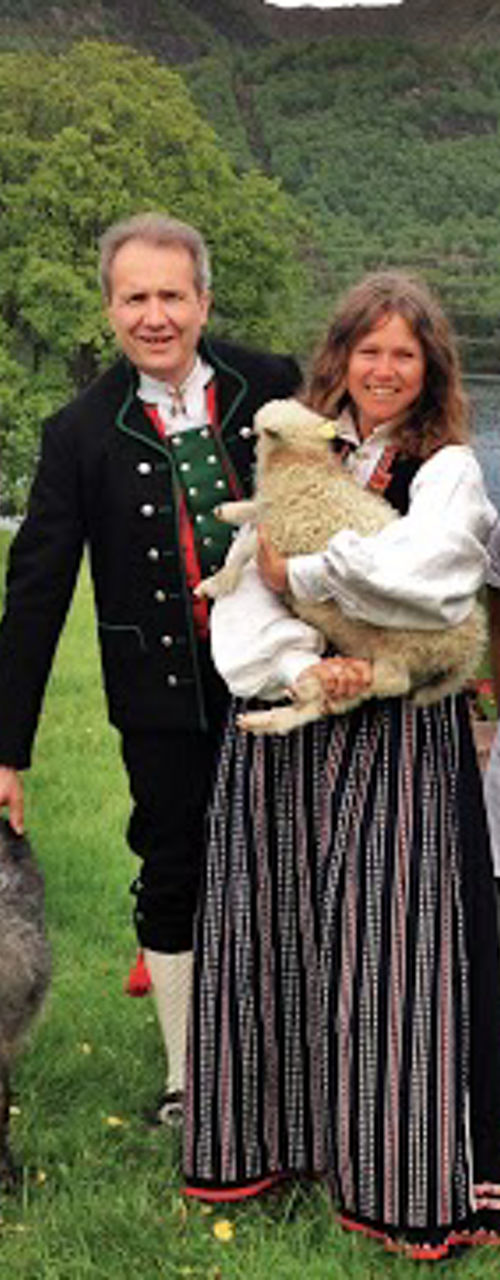Group in traditional attire with animals outdoors