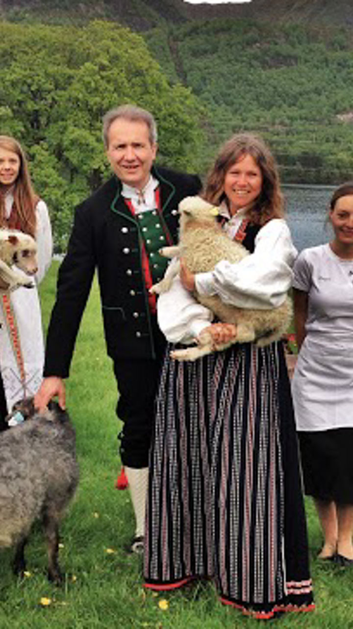 Group in traditional attire with animals outdoors