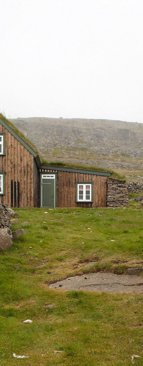 Rustic stone house in grassy landscape