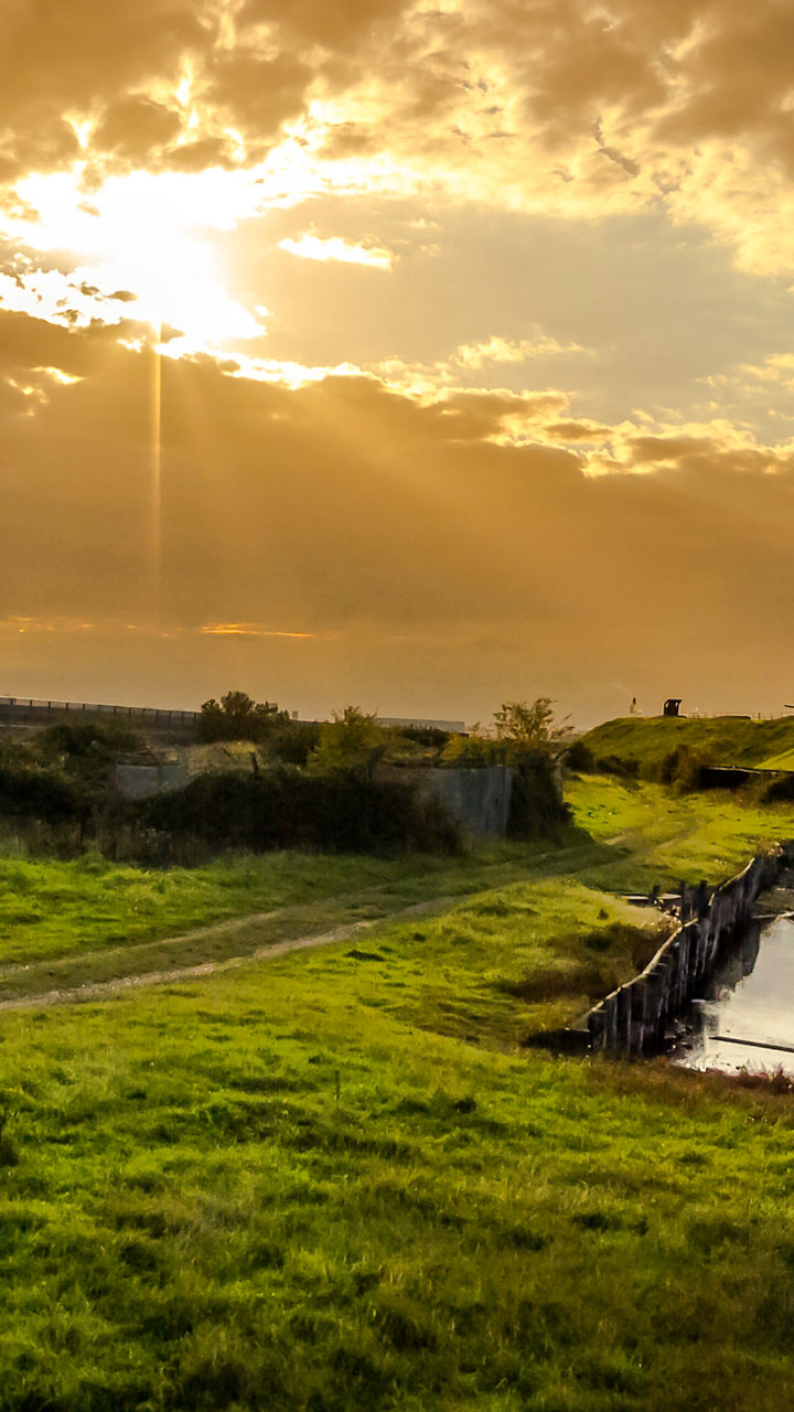 Scenic sunset over rural landscape with windmill