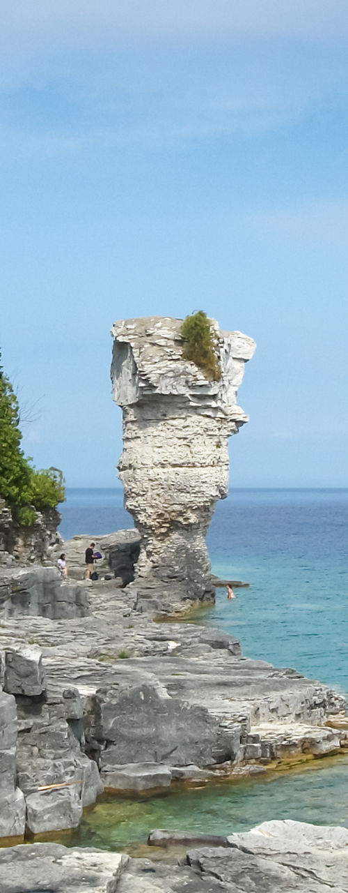 Rock formation by clear blue waters
