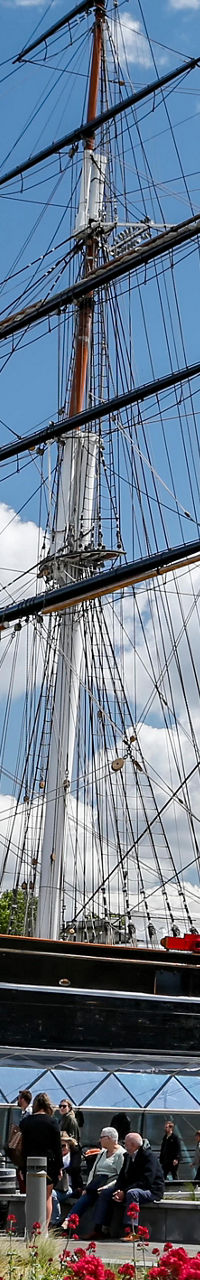 Historic sailing ship in vibrant garden setting