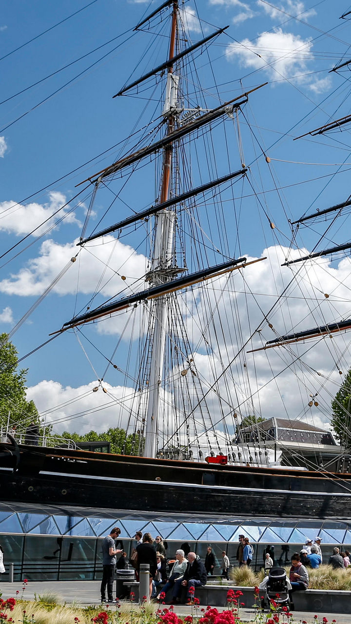 Historic sailing ship in vibrant garden setting