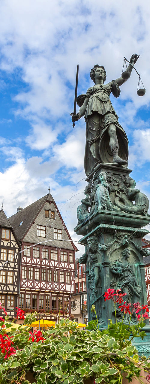 Historic square with statue and flowers