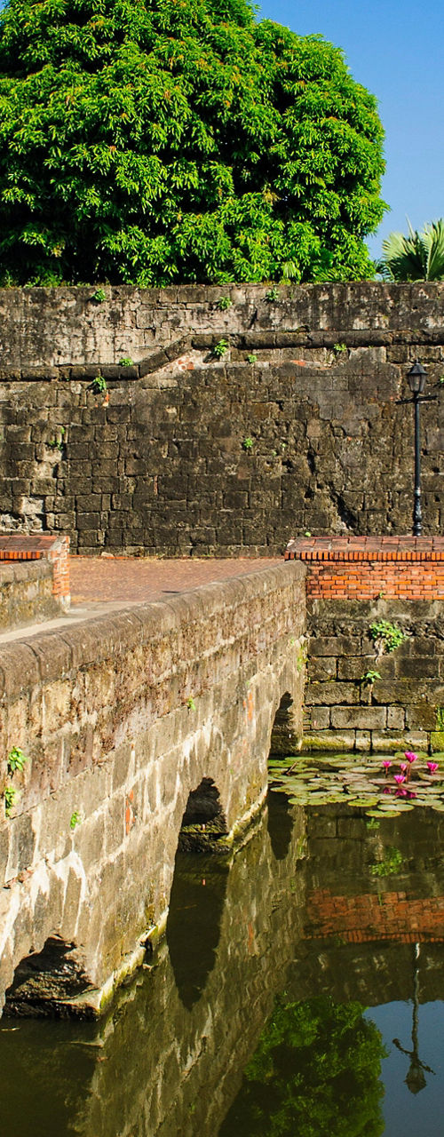 Historic stone fort with water reflection