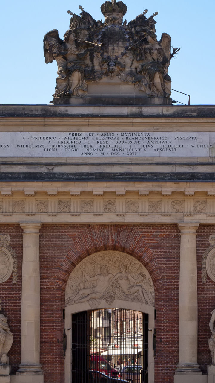 Historic brick archway with flag and statues