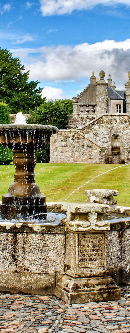 Historic stone fountain in manicured garden