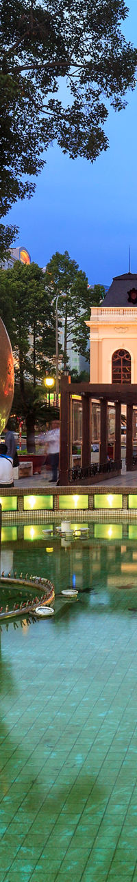 Urban plaza with illuminated fountain at dusk