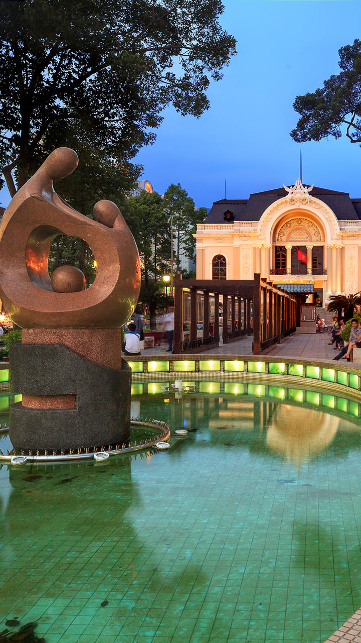 Urban plaza with illuminated fountain at dusk