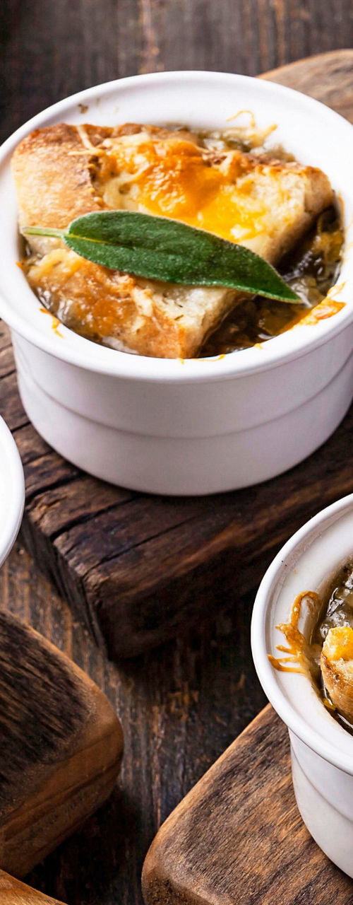 Rustic onion soup in white ramekins