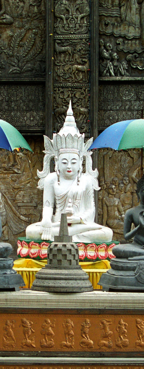 Buddha statues with colorful umbrellas in temple