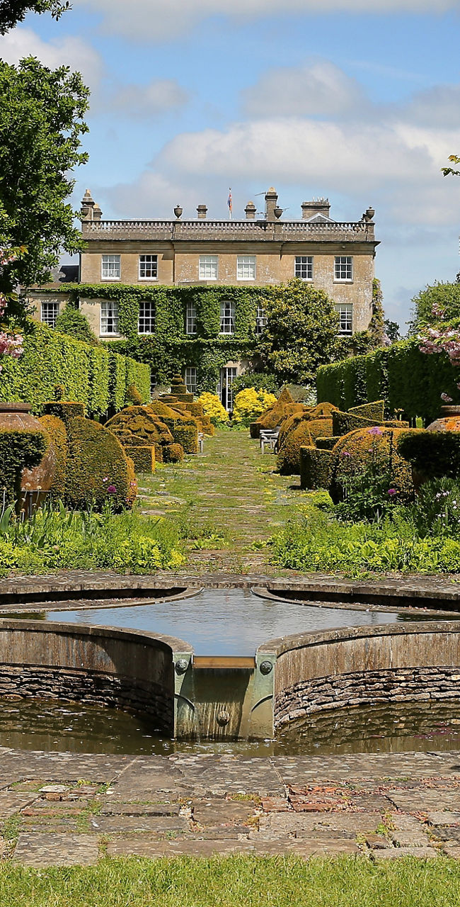 Elegant garden with fountain and manor view