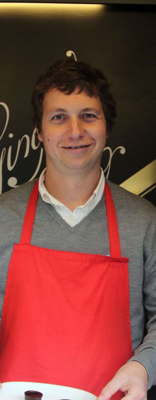 Man in red apron holding chocolates