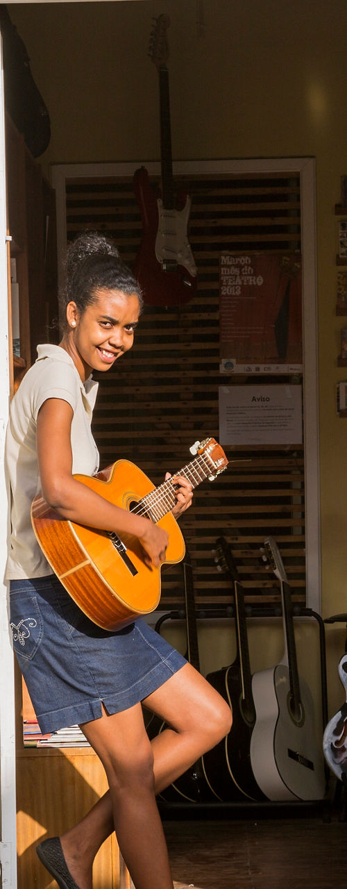 Person playing guitar at shop entrance