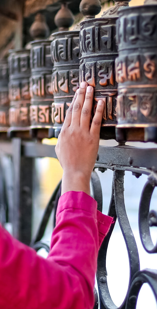 Woman spinning prayer wheels in temple