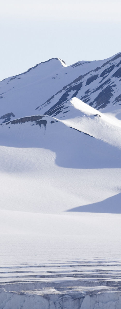 Snowy mountain range with icy waters