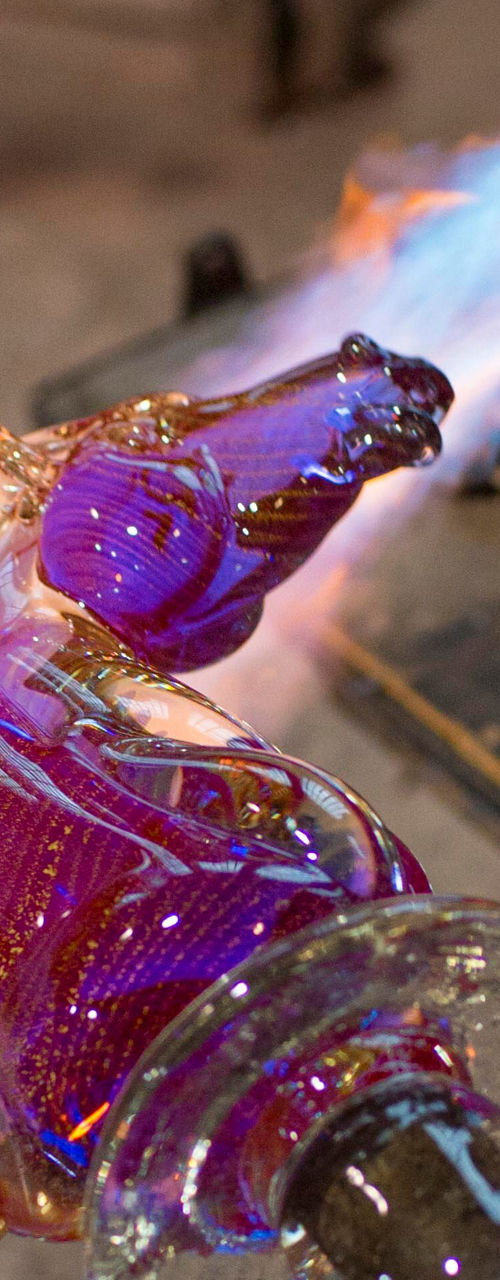 Glassblowing artisan crafting vibrant horse sculpture