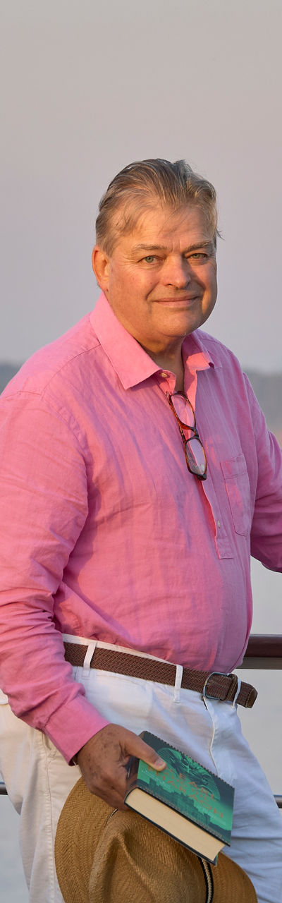 Man in pink shirt by riverside railing
