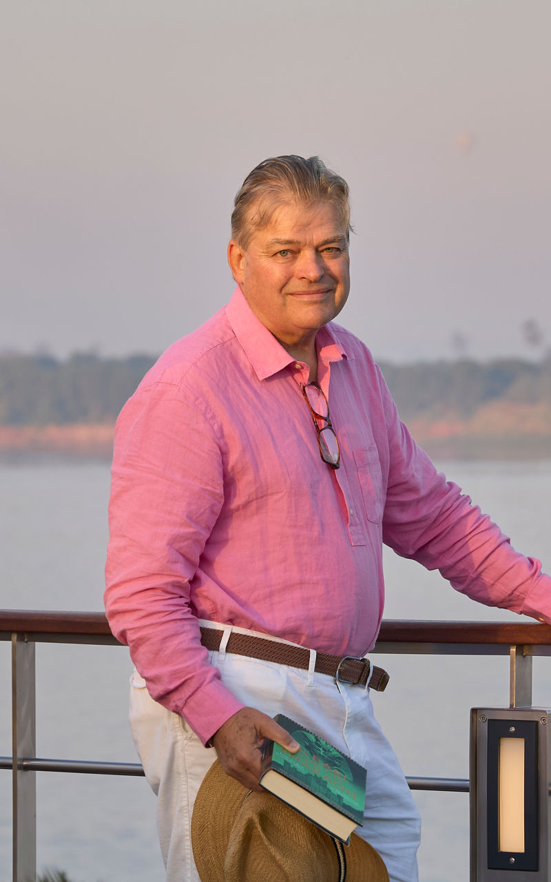Man in pink shirt by riverside railing