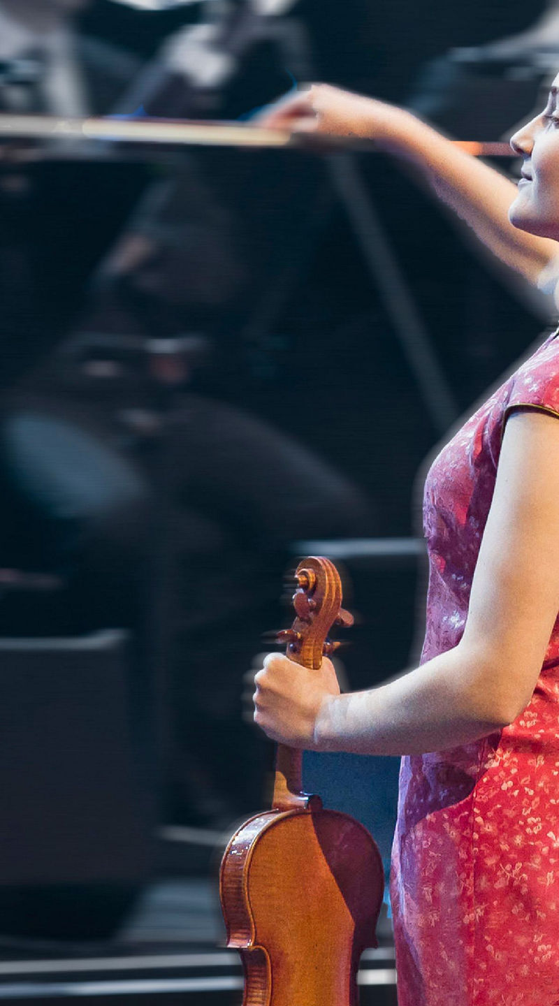 Violinist in red dress performing on stage
