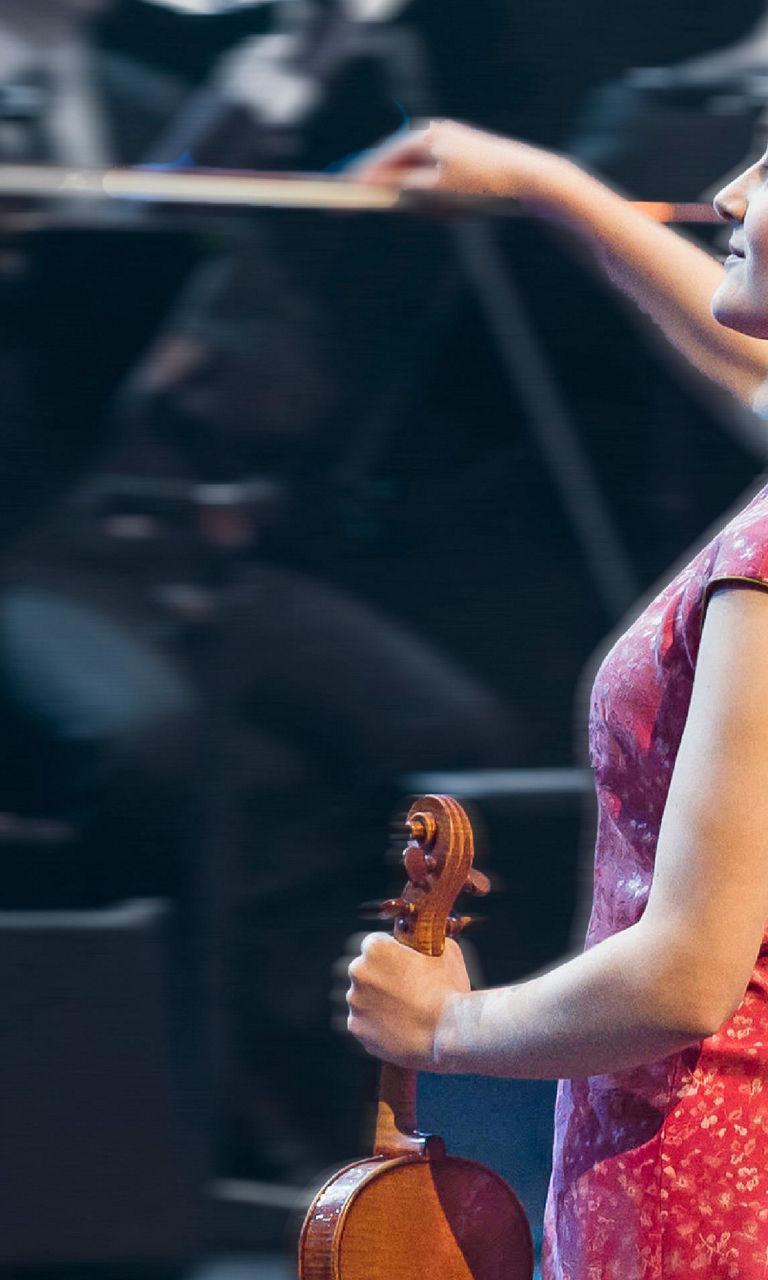 Violinist in red dress performing on stage