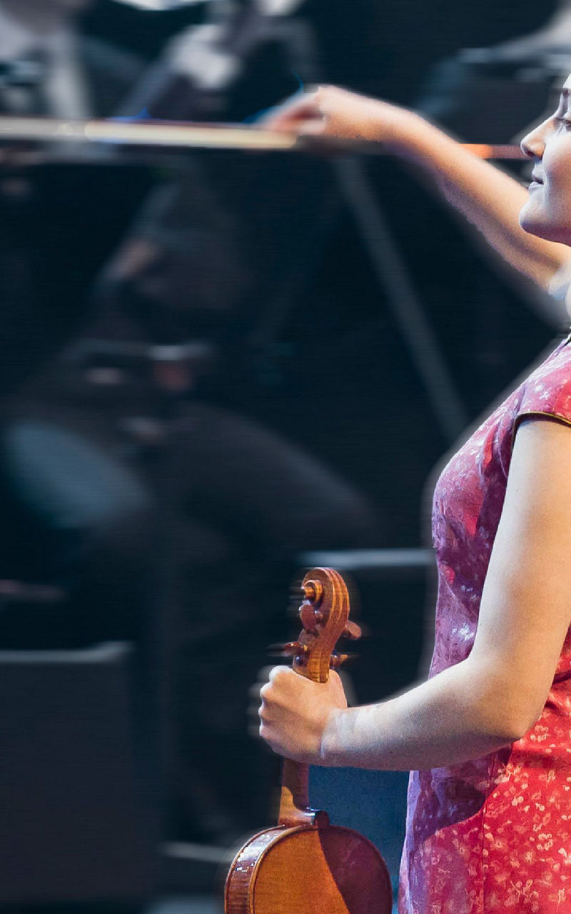 Violinist in red dress performing on stage