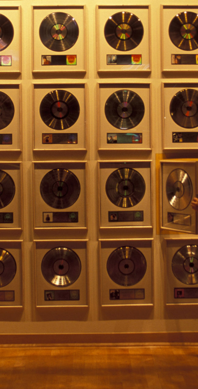 Person admiring wall of gold records