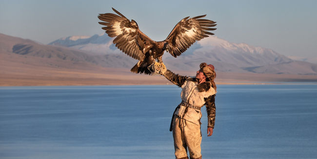 Eagle hunter by serene mountain lake