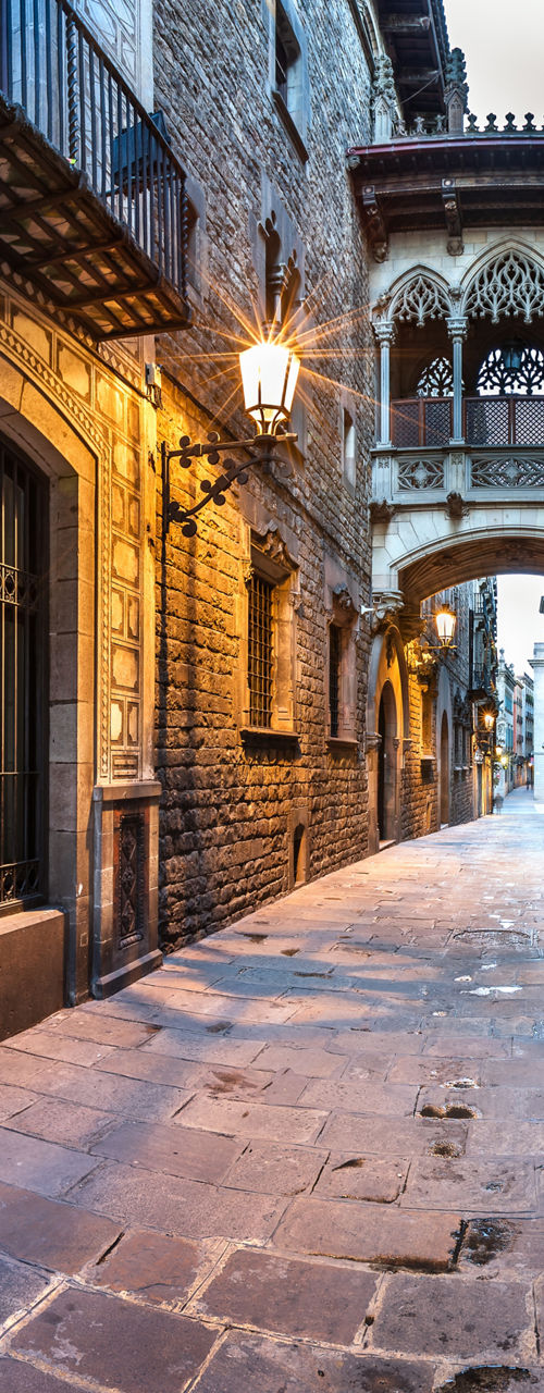 Narrow historic stone alley with arch bridge