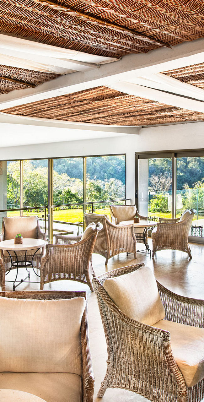 Elegant lounge with wicker seating and scenic views
