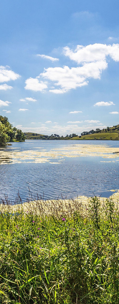Scenic lake surrounded by lush green hills