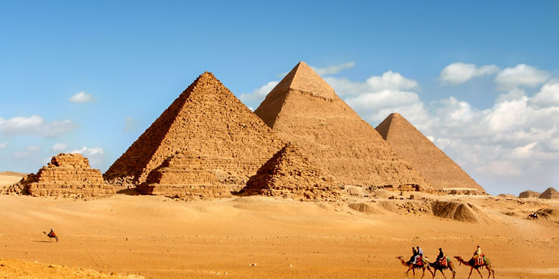 Camel riders near Egyptian pyramids