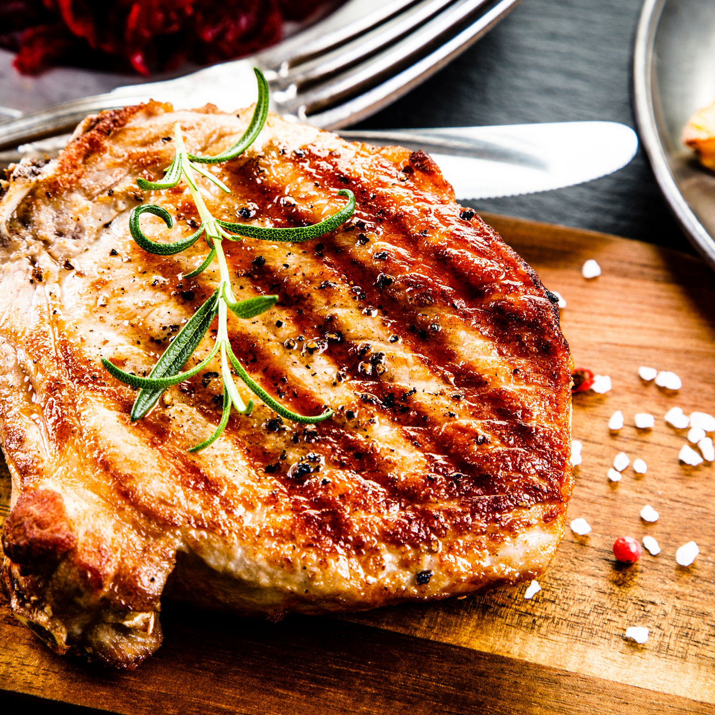 Grilled pork chop with rosemary garnish