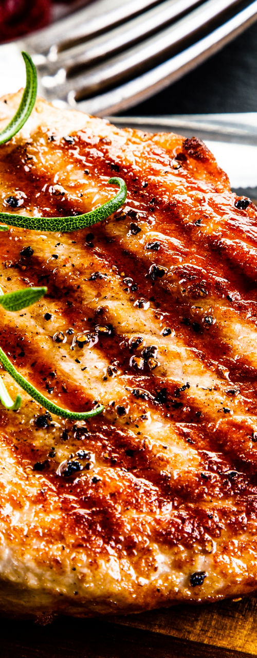 Grilled pork chop with rosemary garnish
