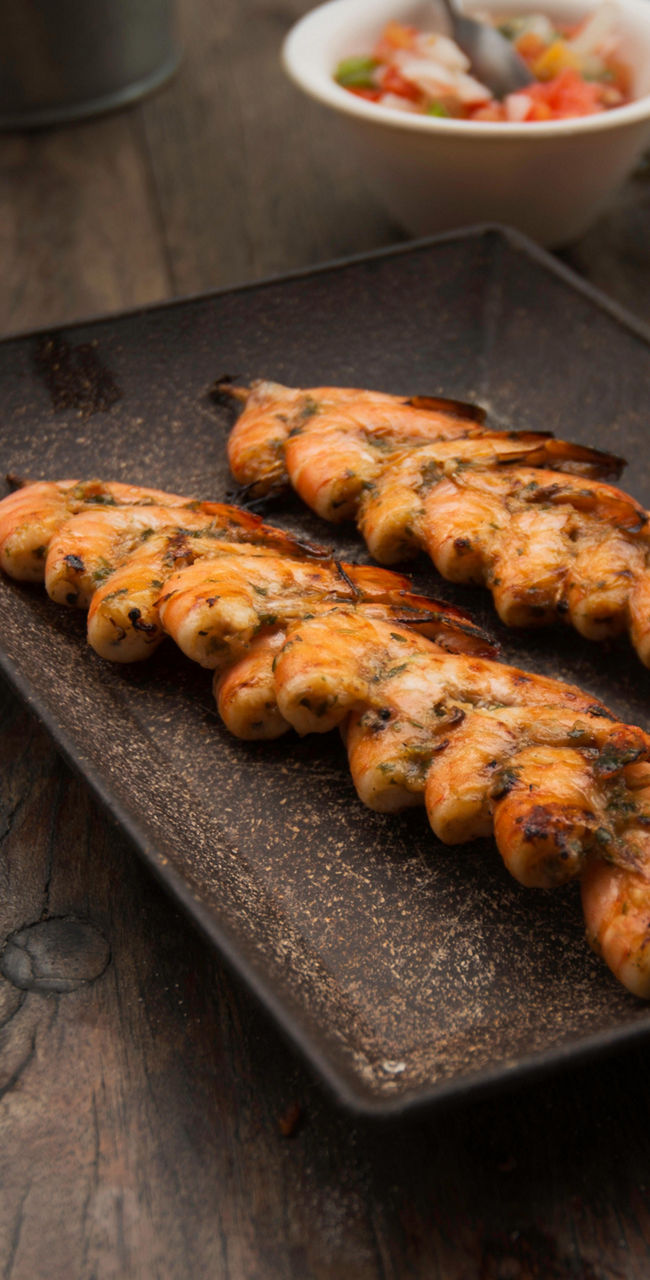 Grilled chicken skewers with drinks on table